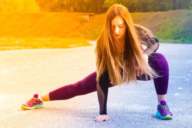 Sağlıklı genç kız stadyumda koşmadan önce bacaklar germe. Kadın koşmadan önce esneiyor. Fitness ve yaşam tarzı kavramı