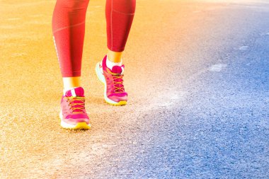 Spor ayakkabıyla koşan sportif kadın, degrade. Koşucu ayakları yolda koşuyor ayakkabıya yakın. Genç fitness kadın çalışan, tonda. Fitness ve egzersiz sağlıklı yaşam konsepti