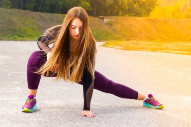 Sağlıklı genç kız stadyumda koşmadan önce bacaklar germe. Kadın koşmadan önce esneiyor. Fitness ve yaşam tarzı kavramı
