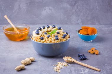 Kahvaltı için yulaf ezmesi, bal ve meyve. Yabanmersinli yulaf ezmesi, muz ve nane. Mısır gevreği, kurutulmuş kayısı ve fındıklı sağlıklı yulaf lapası. Çimentoda pişirilmiş yulaf ezmesi