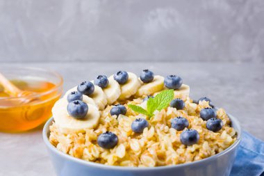 Çilekli yulaf ezmesi. Kahvaltı: yulaf ezmesi, yabanmersini, muz ve bal. Mavi peçetede pişmiş yulaf ezmesi.