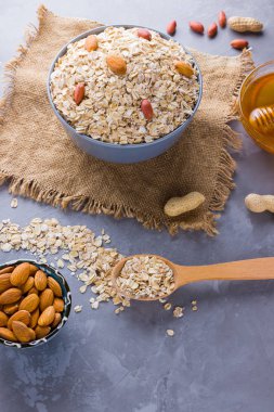 Sağlıklı bir kahvaltı için malzemeler, fındık, yulaf ezmesi, bal, kurutulmuş kayısı, badem, fıstık. Mevsimlik doğal organik gıda kavramı. Çuval bezinde yulaf ezmesi