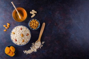 Sağlıklı bir kahvaltı için yulaf ezmesi ve fındık. Kasede yulaf ezmesi ve bal. Kuru yulaf ezmesi, badem ve kurutulmuş kayısı. Yiyecek konsepti