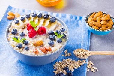 Kahvaltıda böğürtlenli ve fındıklı ev yapımı yulaf ezmesi. Meyveli, fındıklı ve ballı yulaf ezmesi. Yabanmersinli yulaf ezmesi, muz ve ahududu.