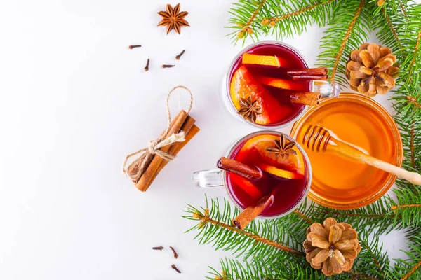 Mulled wine in glass mug with spices. Glasses of mulled wine with cinnamon, anise and fir tree branches. Winter Christmas drink. Top view. Flat lay