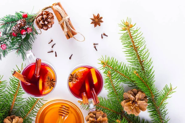 Mulled wine in glass mug with spices. Glasses of mulled wine with cinnamon, anise and fir tree branches. Winter Christmas drink. Top view. Flat lay