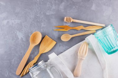Sıfır atık. Pamuk çanta, cam ve gri arka planda tahta çatal bıçak. Çevre dostu ahşap çatal bıçak seti ve mason kavanozu. Plastiksiz konsept. Minimalizm. Üst Manzara. Boşluğu kopyala