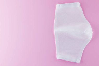 Pembe arka planda koruyucu gazlı bez maskesi. Beyaz antivirüs maskesi. Pamuktan yapılmış el yapımı tıbbi maske. Gazlı bezden yapılmış koruyucu yüz maskesi. Üst Manzara. Boşluğu Kopyala