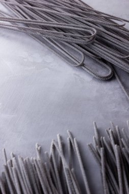Gri arka planda siyah makarna. Çimento arka planında siyah spagetti. Mürekkepbalıklı çiğ spagetti. Yemek geçmişi konsepti. Üst Manzara. Boşluğu kopyala