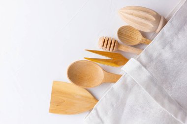 Sıfır atık. Beyaz arka planda pamuk çanta ve ahşap çatal bıçak takımı. Çevre dostu ahşap çatal bıçak takımı ve ekolojik çanta. Plastiksiz konsept. Minimalizm. Boşluğu kopyala