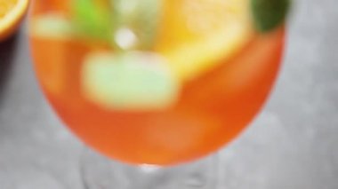 Gri arka planda Aperol Spritz kokteyli. Portakallı İtalyan alkolü kokteyli. Aperol Spritz ve taze nane ile dilimlenmiş portakal.
