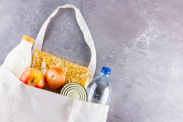 Food donations in linen bag. Food delivery in eco bag. Eco bag with food supplies food stock. Top view. Copy space