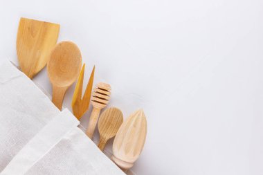 Sıfır atık. Beyaz arka planda pamuk çanta ve ahşap çatal bıçak takımı. Çevre dostu ahşap çatal bıçak takımı ve ekolojik çanta. Plastiksiz konsept. Minimalizm. Boşluğu kopyala