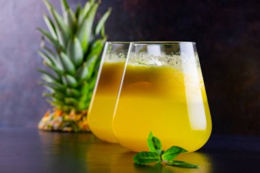 Siyah arka planda ananas suyu. Bardakta detoks sıvısı var. Taze ananaslı ananas püresi. Karanlık bir arka planda sağlıklı bir içecek.
