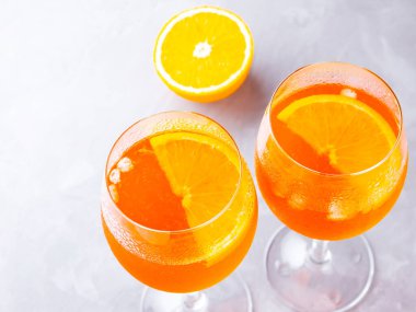 Gri arka planda Aperol sprey kokteyli. İki bardak portakallı aperol spreyi. Bardakta yaz kokteyli. Üst Manzara. Boşluğu kopyala