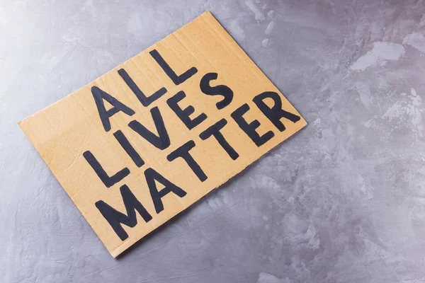 ALL LIVES MATTER. Anti racism concept on a gray background. Equal symbol. Inscription on cardboard 