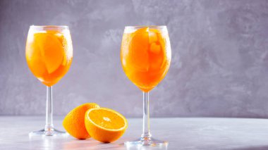 Gri arka planda Aperol sprey kokteyli. İki bardak portakallı aperol spreyi. Bardakta İtalyan kokteyli. Boşluğu kopyala