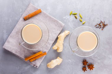 Masala çayı. Geleneksel Hint içeceği. Gri arka planda baharatlar olan Masala çayı. Üst görünüm