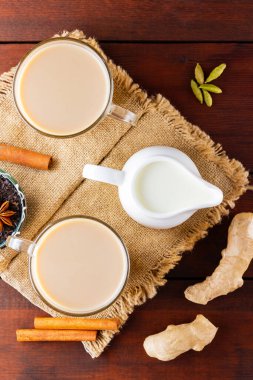 Çuval bezinde Masala çayı. Geleneksel Hint içeceği. Ahşap arka planda baharatlar olan Masala çayı. Üst görünüm
