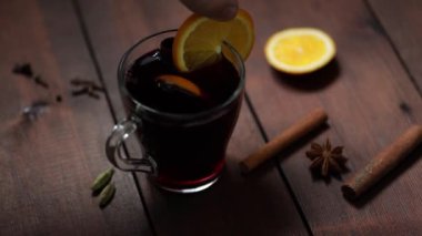 Ahşap arka planda sıcak şarap, yukarıdan manzara. Sonbahar sıcak şarap ve baharatlar. Kırsal tarzda sıcak bir Noel içeceği. Yavaş çekim