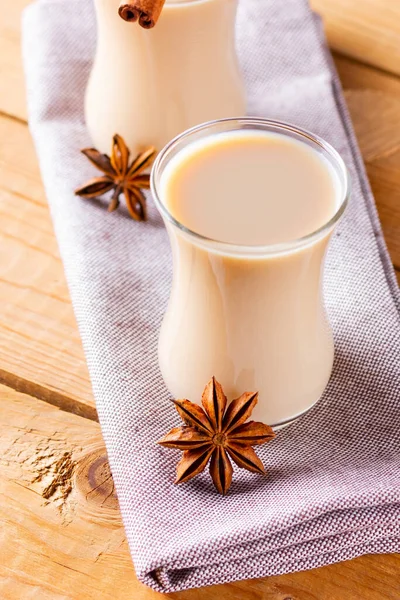 Herb tea with milk and spices. Homemade Indian Masala Chai Tea on wooden boards. Autumn drink in turkish tea cups