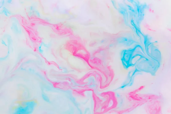 Fluid art. Multicolored background from liquid. Photography of colored spots on liquid. Abstract pattern