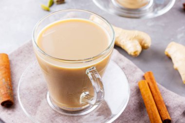Masala çayı. Geleneksel Hint içeceği. Gri arka planda baharatlar olan Masala çayı. Üst görünüm