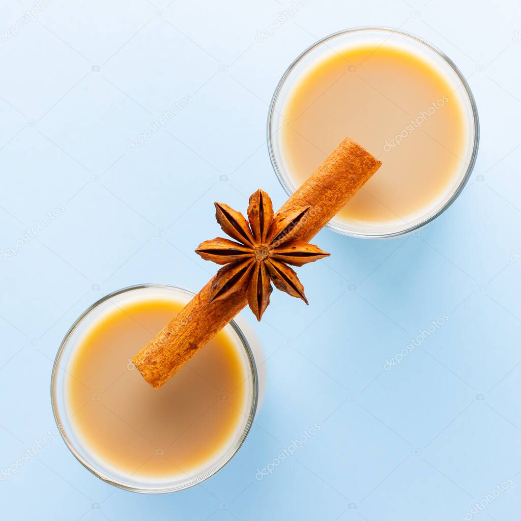 Tea with milk and spices on a blue background. Masala chai in turkish tea cups. Indian national drink on a pastel background. Top view