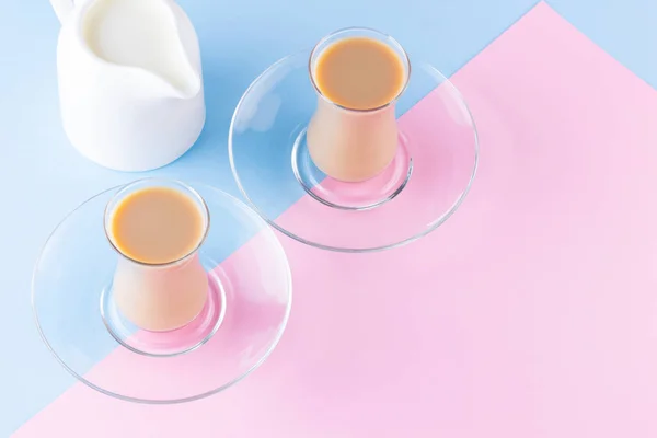 ピンクブルーの背景にミルクティー トルコのティーカップとミルクジュグ 牛乳と伝統的な英語の紅茶のカップ コピースペース トップ表示 — ストック写真