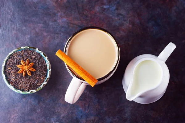 マサラチャイ茶 伝統的なインドの飲み物 暗い背景にスパイスとマサラ茶 スパイスティーと白ミルクジュグのセラミックカップ — ストック写真