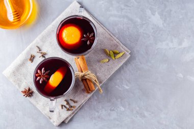 Gri arka planda sıcak şarap. İki bardak sonbahar şarabı keten bir peçeteye konmuş. Noel içkisi. Uzayı kopyala Üst görünüm