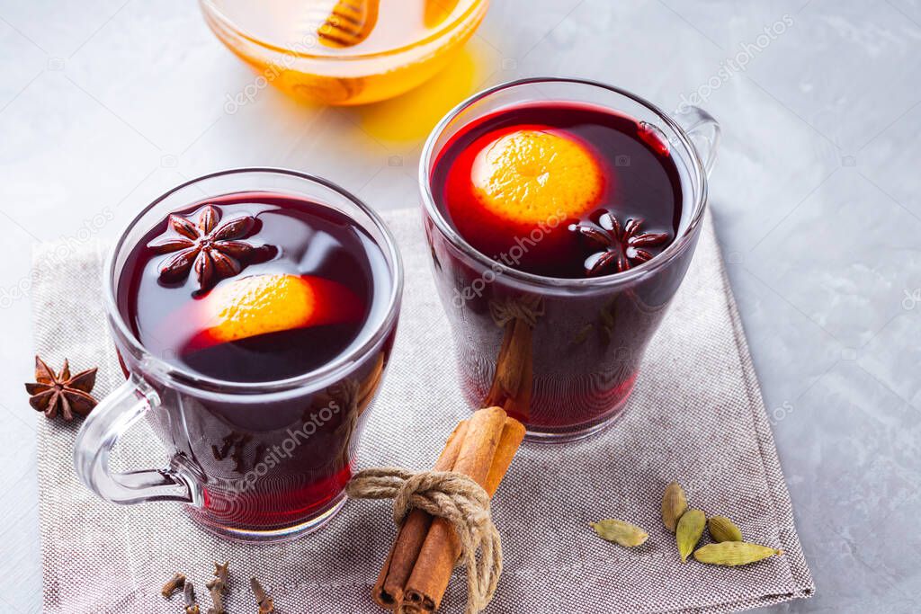 Mulled wine on a gray background. Two cups of autumn mulled wine on a linen napkin. Christmas hot drink. Copy space. Top view