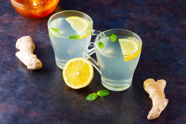 Koyu arkaplanda limonlu zencefil çayı. Hazırlamak için iki fincan zencefilli çay ve malzeme.