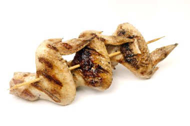 yalıtım için beyaz bir arka plan üzerinde bir şiş üzerinde sinirli bir ızgarada kızartılmış tavuk kanadı