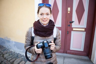 Kız fotoğrafçı gezgin eski şehrin sokaklarında yürüyor