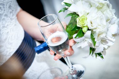 Çiçekli şık bir gelin ve elinde şampanya kadehi, içkiler. Düğün töreni. Eller yukarı.