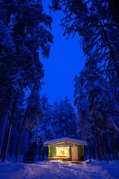 Paisagem de conto de fadas de inverno - Casa de madeira com luz quente na floresta de inverno nevado noite, tamanho grande — Fotografia de Stock