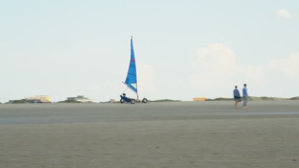 Земля вітрильний спорт - пілота в вітрила вагона рулонах через пустельний пляж піщаний — стокове відео