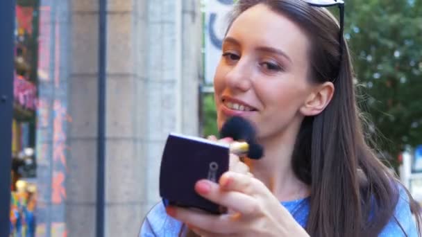 Dívka použití make-up, zatímco ona čeká na svého přítele v městě — Stock video