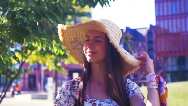 Retrato de uma jovem mulher bonita usando um chapéu em um dia ensolarado de verão . — Vídeo de Stock