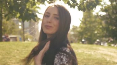 Güzel bir genç kız kamera önünde poz veriyor ve saçlarını sinek sağlar