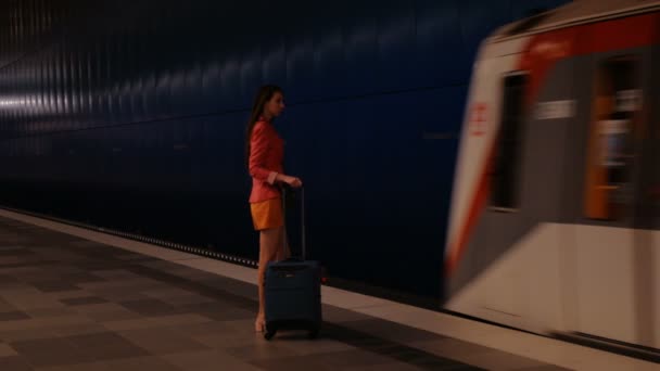 On the business trip - a young modern woman with a suitcase takes her train — Stock Video