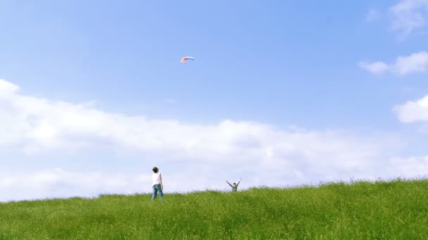 Moeder en zoon vliegende vlieger in blauwe hemel met wat wolken. — Stockvideo