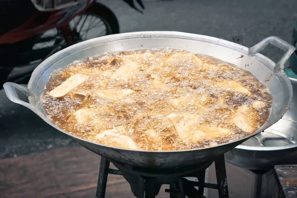 frying food in hot oil deep fried boiling food oil in pan street food in Thailand