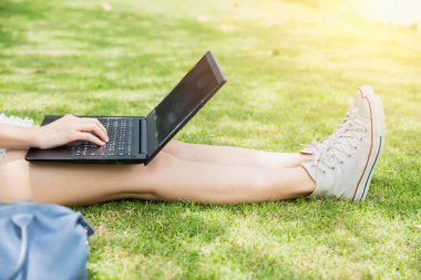 Teen öğrenci bilgisayar dizüstü bilgisayar açık Üniversitesi Kampüs yeşil park kavramı ile çalışma.