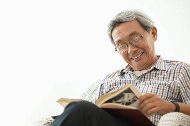 Beyaz oda oturma okuma sırasında Asya yaşlı gülümse