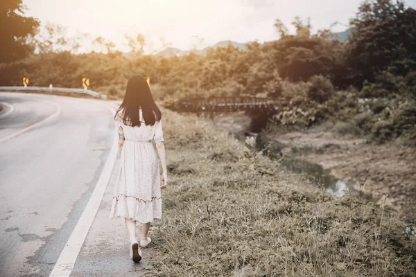 girl walk away  alone woman walking lonely at roadside