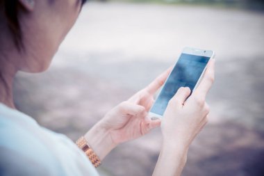 closeup kadınlar iki elini tut smartphone seyir kullanarak ekran vintage sanat renk tonu okuyun