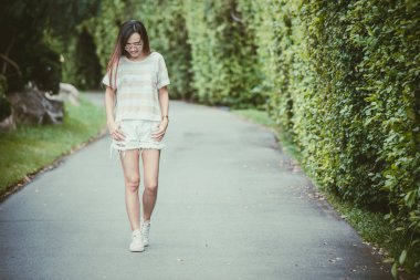 tatil vintage renk tonu Asya ince hippi kız giyiyor güneş gözlüğü gülümseyen yeşil parkta yürüyüş rahatla