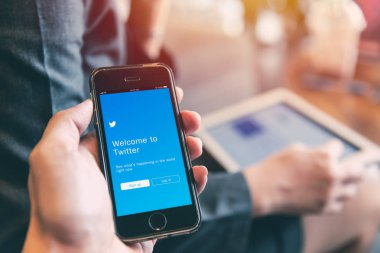 Twitter App iPhone tablet arka plan closeup erkek el kullanan kişiler ile tutun sosyal ağ üzerinde akıllı aygıt concept.23 Eylül 2018, Bangkok Tayland.